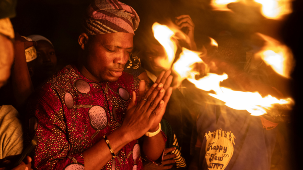 Homem realizando um ritual espiritual, simbolizando a importância de encontrar um Pai de Santo confiável para garantir que o Selamento Espiritual ou qualquer outro trabalho espiritual seja feito com seriedade e ética.