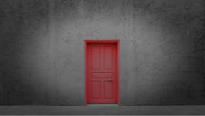 Uma porta vermelha destacada em uma parede cinza escura, simbolizando a pessoa não tem abertura caminhos e oportunidades.