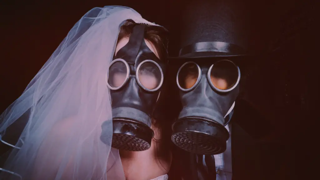 Casal vestido com trajes de casamento — a noiva com véu branco e o noivo com cartola — ambos usando máscaras de gás, simbolizando um relacionamento sufocante e tóxico. A imagem representa visualmente os efeitos prejudiciais da dependência afetiva em relacionamentos, destacando a sensação de aprisionamento emocional e desgaste psicológico.