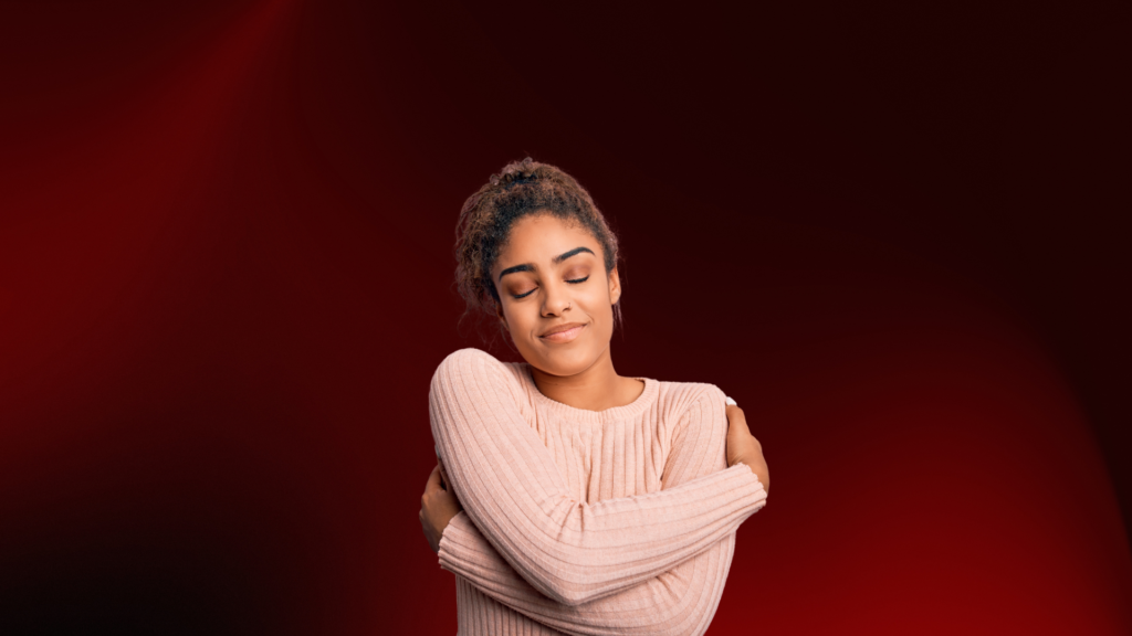 Mulher de olhos fechados sorrindo e abraçando a si mesma, transmitindo amor-próprio, paz interior e libertação de relações tóxicas.
