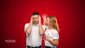 Homem tapa os ouvidos enquanto mulher grita com ele, simbolizando tensão em briga de casal.