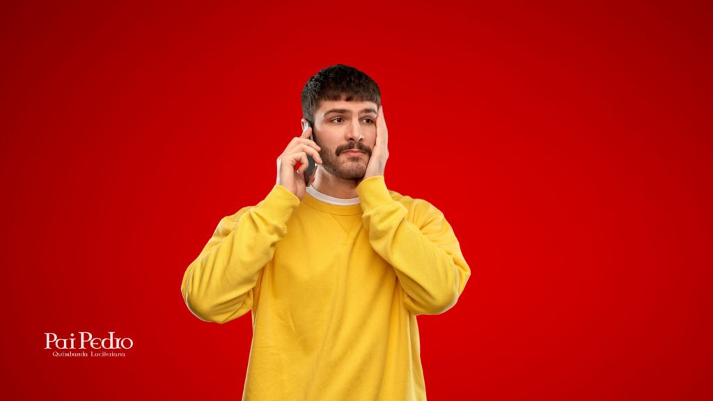 Homem de expressão confusa e preocupada ao telefone, vestindo moletom amarelo, sobre fundo vermelho. Representa a frustração de quem vive um relacionamento confuso, onde o outro Ele não quer nada sério, mas me procura.