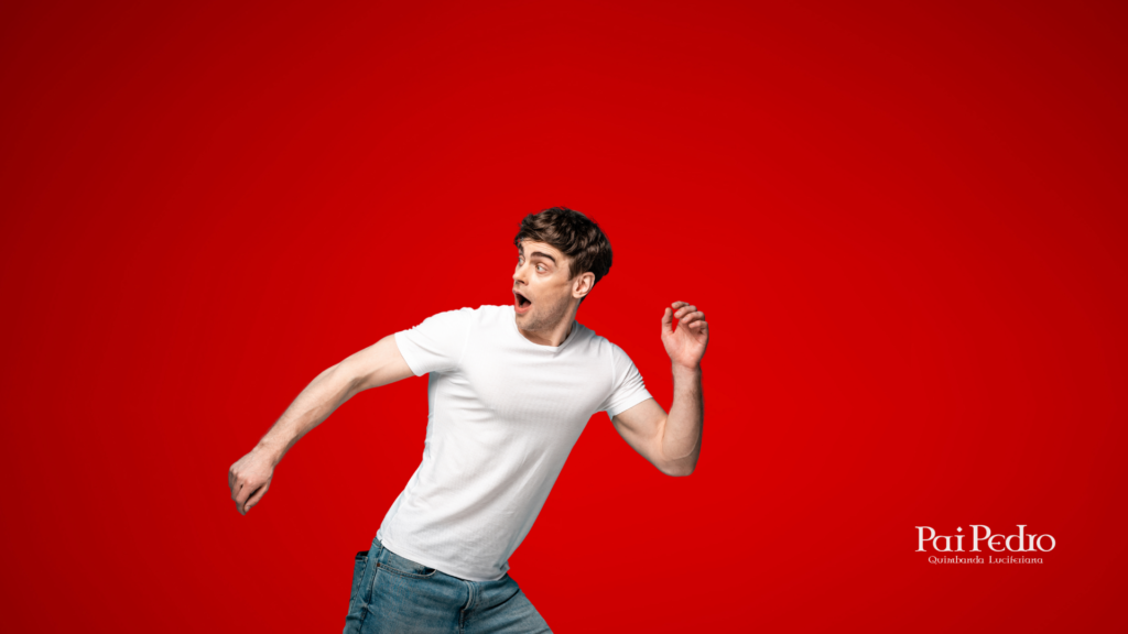 Homem com expressão de surpresa e movimento de fuga, representando a reação de alguns homens ao se apaixonarem, sobre fundo vermelho intenso.