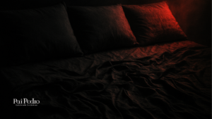 Cama desarrumada com três travesseiros, iluminada por uma luz vermelha dramática no canto, simbolizando mistério, intensidade e a presença de múltiplos envolvidos — remetendo às complexidades de um relacionamento aberto.