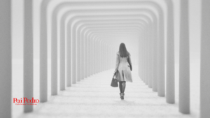 Mulher caminhando sozinha por um corredor futurista e branco, formado por colunas simétricas que se estendem ao infinito. Ela veste sobretudo, carrega uma bolsa e anda com firmeza em direção à luz. A imagem transmite a atitude de se afastar de alguém. No canto inferior esquerdo, o logotipo “Pai Pedro – Quimbanda Luciferiana” em vermelho.